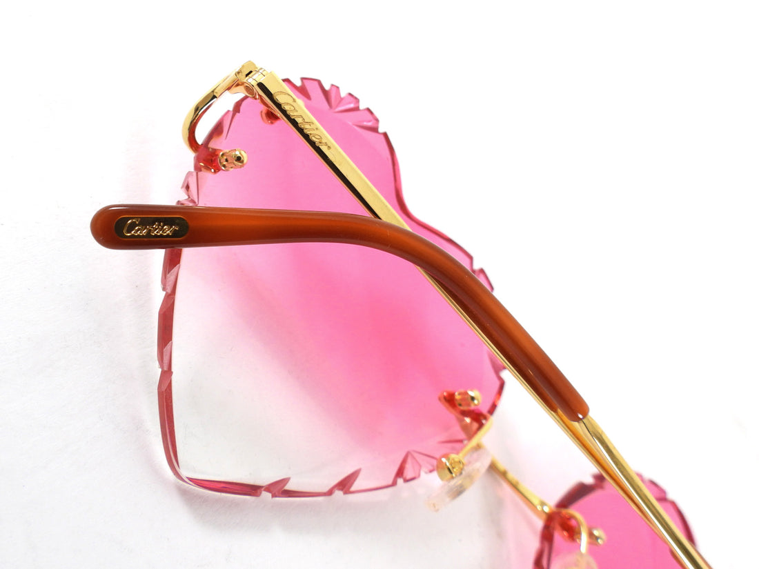 Sunglasses with pink lenses and gold frame on a white background