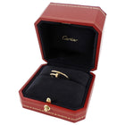 Red Cartier jewelry box with a gold ring inside on a white background