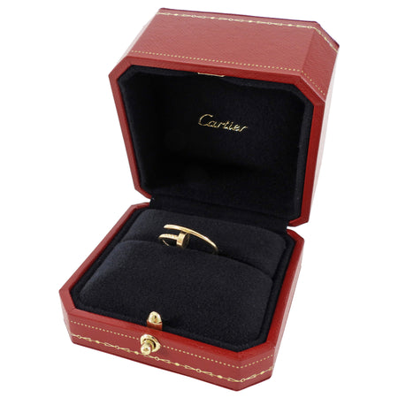 Red Cartier jewelry box with a gold ring inside on a white background