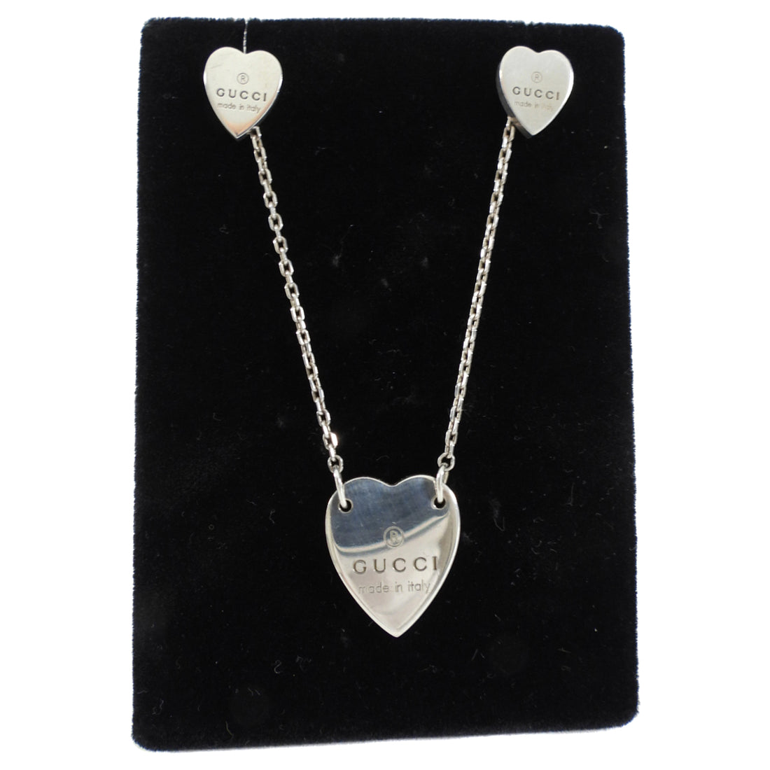 Heart-shaped Gucci earrings on a black display card