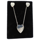 Heart-shaped Gucci earrings on a black display card