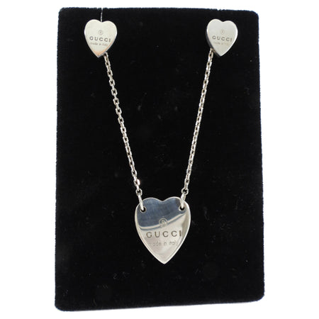 Heart-shaped Gucci earrings on a black display card