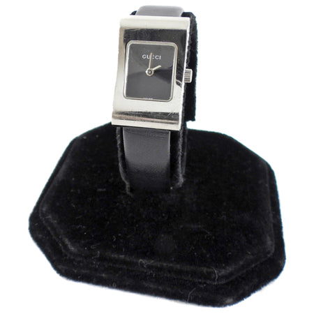 Gucci watch on a black stand with a white background
