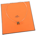 Hermes necklace on an orange Hermes packaging box