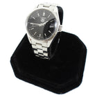 Tag Heuer watch on a black stand with a white background
