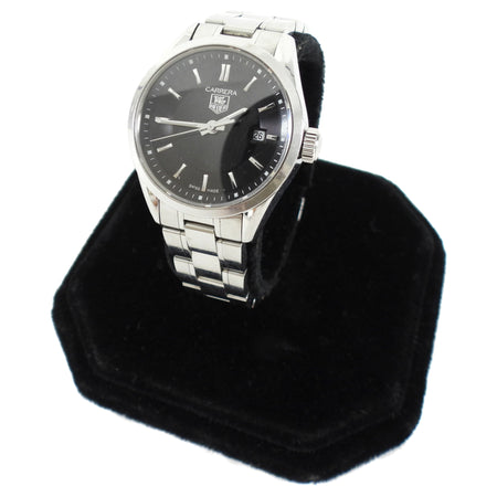 Tag Heuer watch on a black stand with a white background