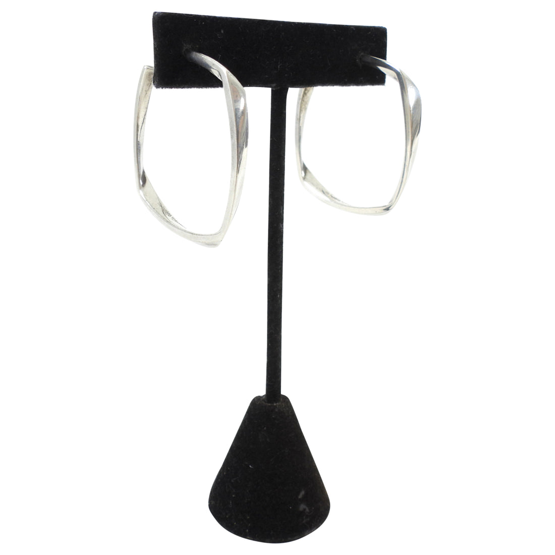 Tiffany & Co. x Frank Gehry Silver hoop earrings on a black earring stand against a white background