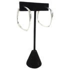 Tiffany & Co. x Frank Gehry Silver hoop earrings on a black earring stand against a white background