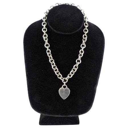 Tiffany & Co. Silver chain necklace with a heart pendant on a black velvet stand.