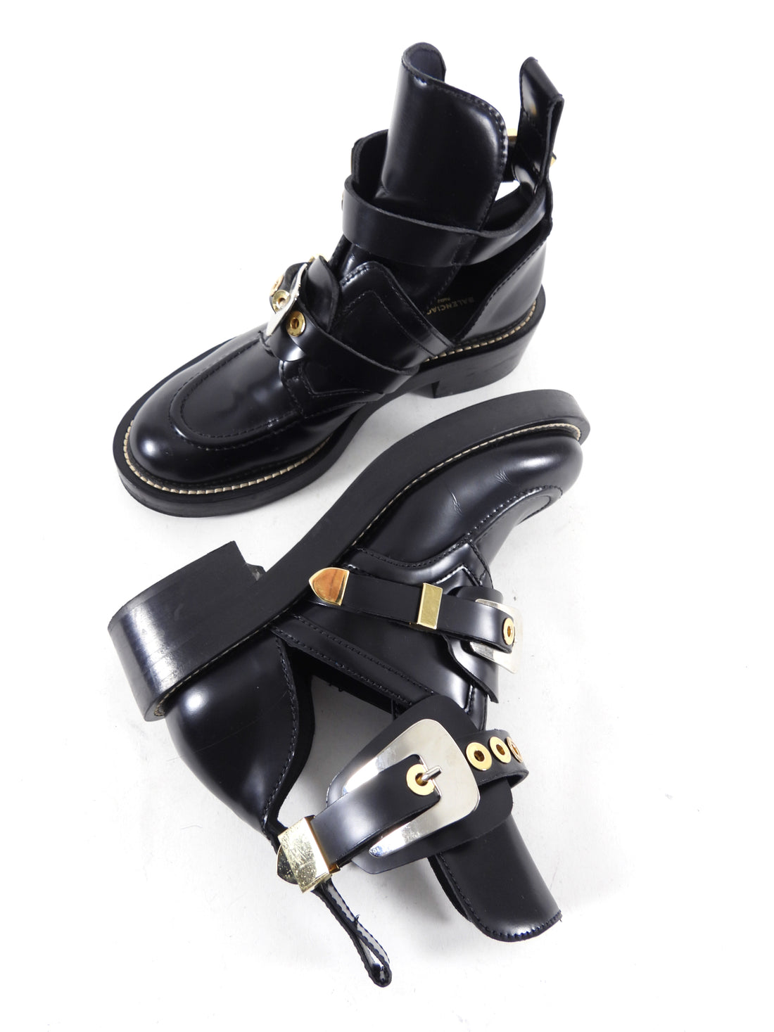 Balenciaga Black Buckle Ankle Boots.  Black gloss leather upper with mixed metal goldtone and silvertone hardware.  Rounded toe, buckle strap detail, cut-out design.  Marked size 37 but French sizing runs small so best for a 36.5.  Excellent pre-owned condition.  Without duster or box.