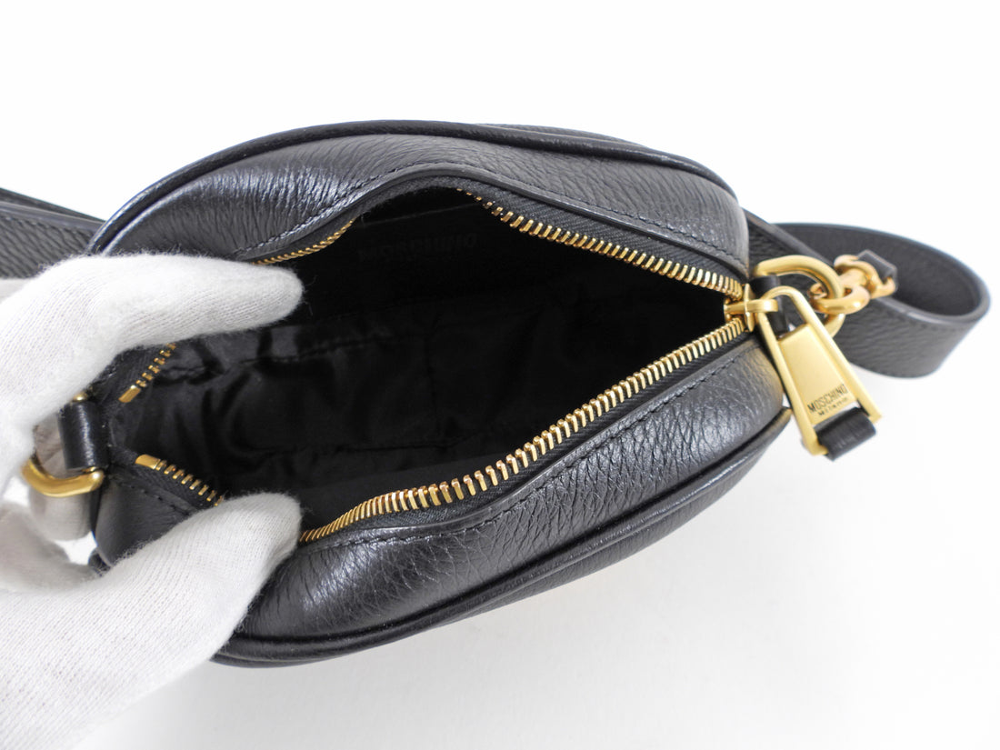Moschino Couture Black Leather Fanny Pack Belt Bag.  Original retail $1151 CAD.  Black leather oval belt bag with logo letters.  Measures 7 x 4 x 2".  Belt has holes every inch from 33-38".  Brand new with tags attached including original price tag from The Room. Includes hang tag, price tag, care paper, and Moschino authenticity card. 