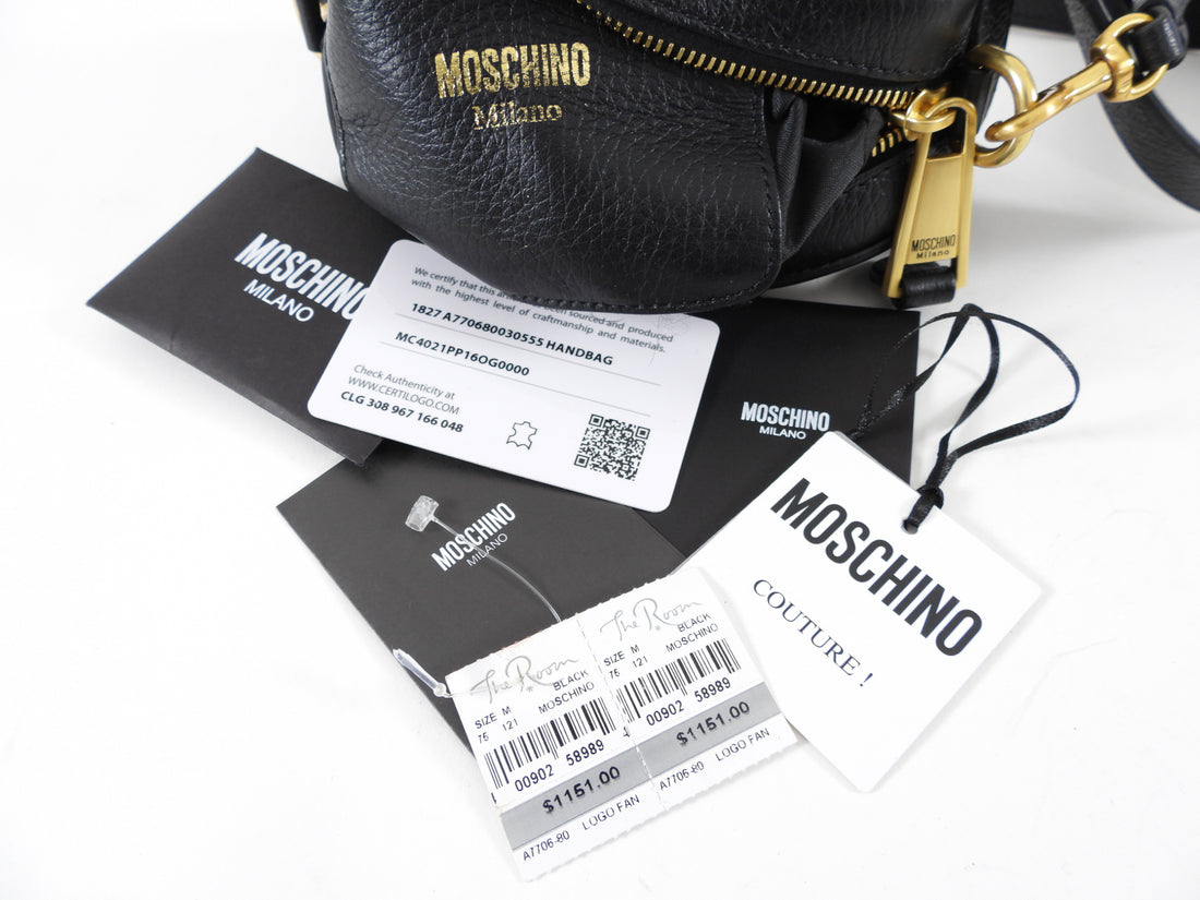 Moschino Couture Black Leather Fanny Pack Belt Bag.  Original retail $1151 CAD.  Black leather oval belt bag with logo letters.  Measures 7 x 4 x 2".  Belt has holes every inch from 33-38".  Brand new with tags attached including original price tag from The Room. Includes hang tag, price tag, care paper, and Moschino authenticity card. 