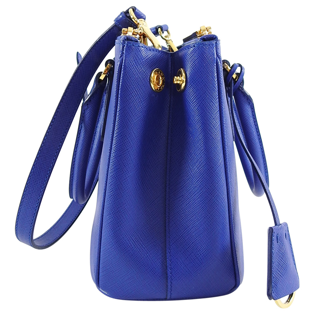 Prada Saffiano Cobalt Blue Mini Galleria Tote Bag.  Current original retail price is $2550 CAD. Goldtone metal hardware, logo at front, double handles, double zippered compartment, clochette, long shoulder strap.  Measures 10.25 x 7 x 4” with a 23” strap drop.  Includes authenticity card and care paper. 